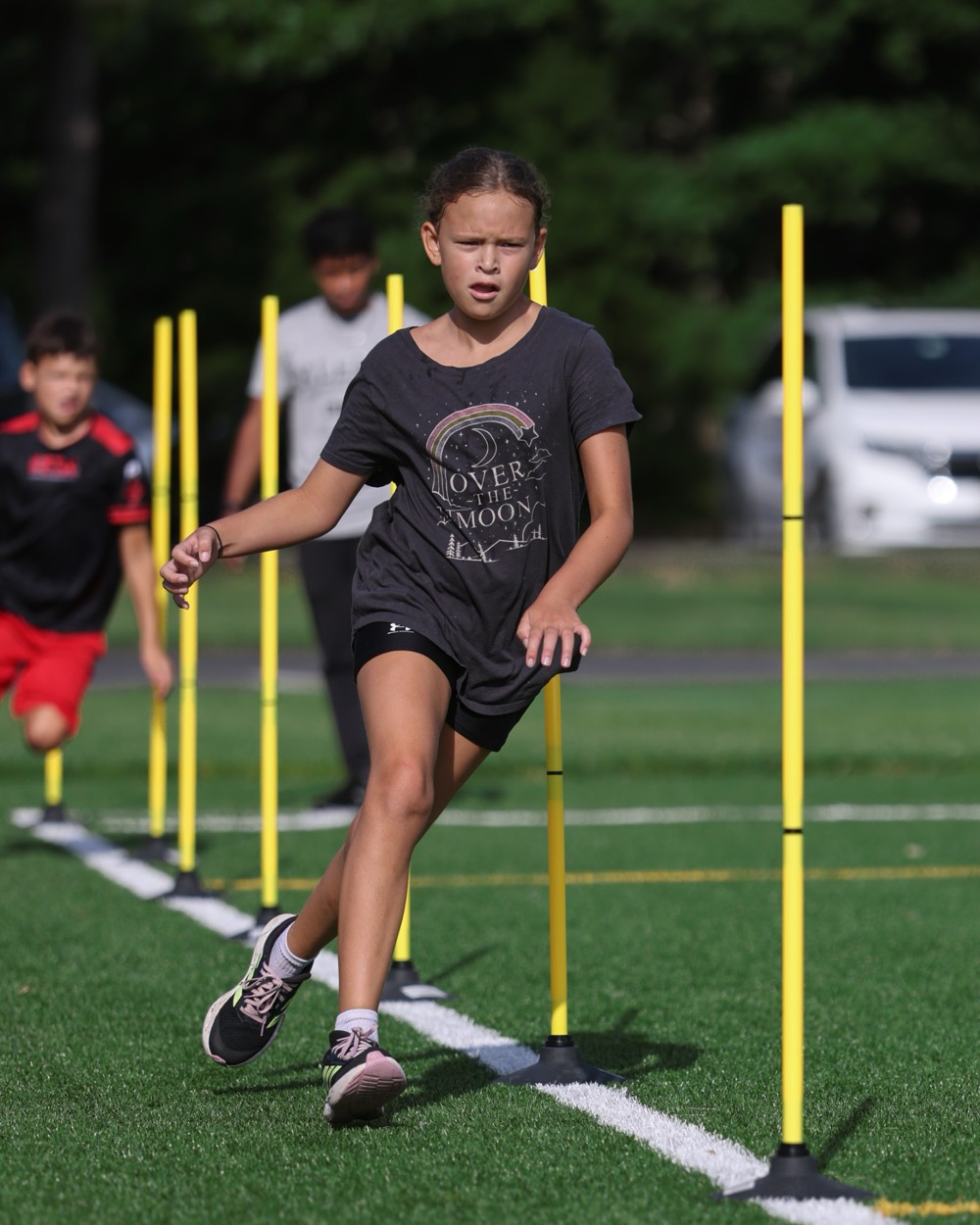 A young athlete cutting through a line of poles in a change-of-direction drill