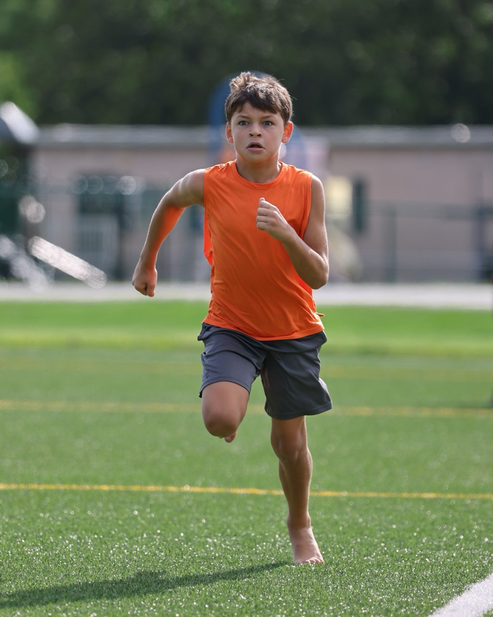 A young athlete sprinting across the turf during a session