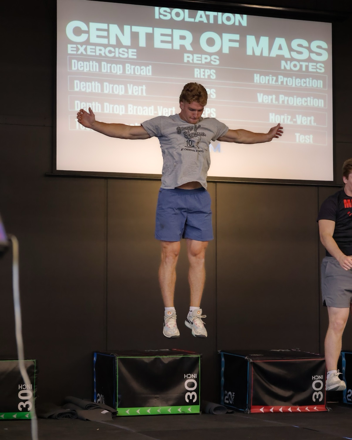An athlete at the top of a depth jump during a center-of-mass session