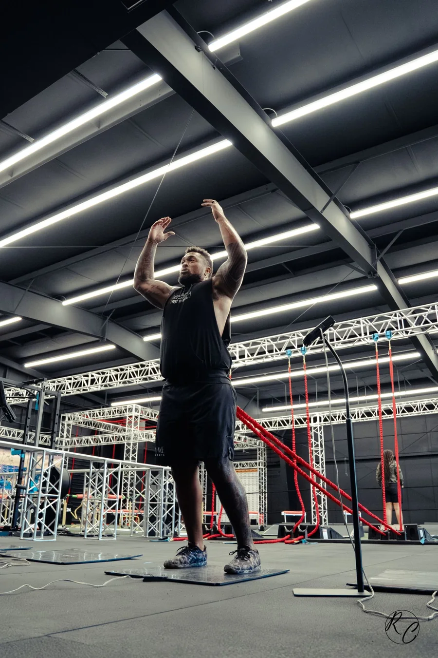 A KPM athlete on the mat, arms overhead at the start of a measured vertical jump