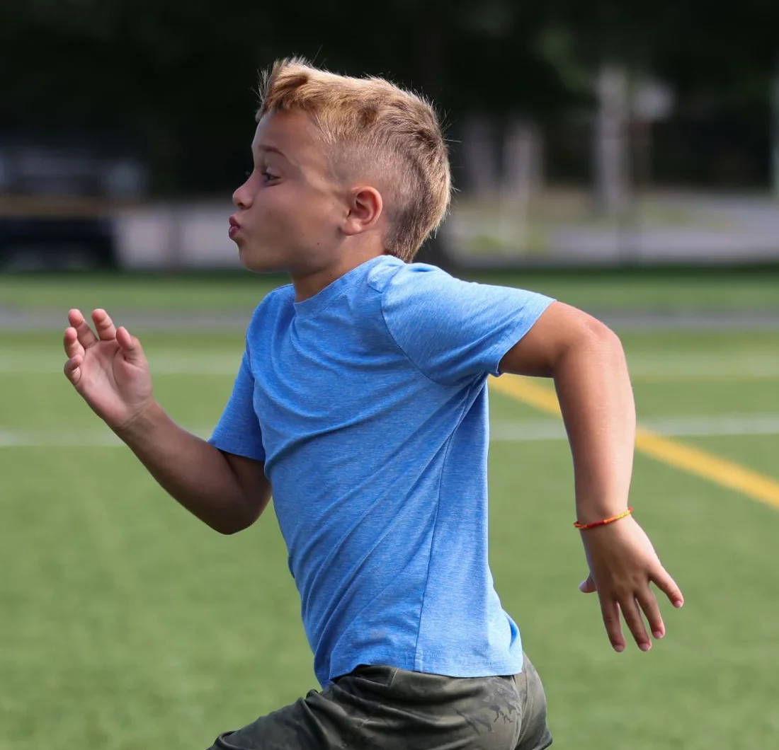 A boy at full stride on turf