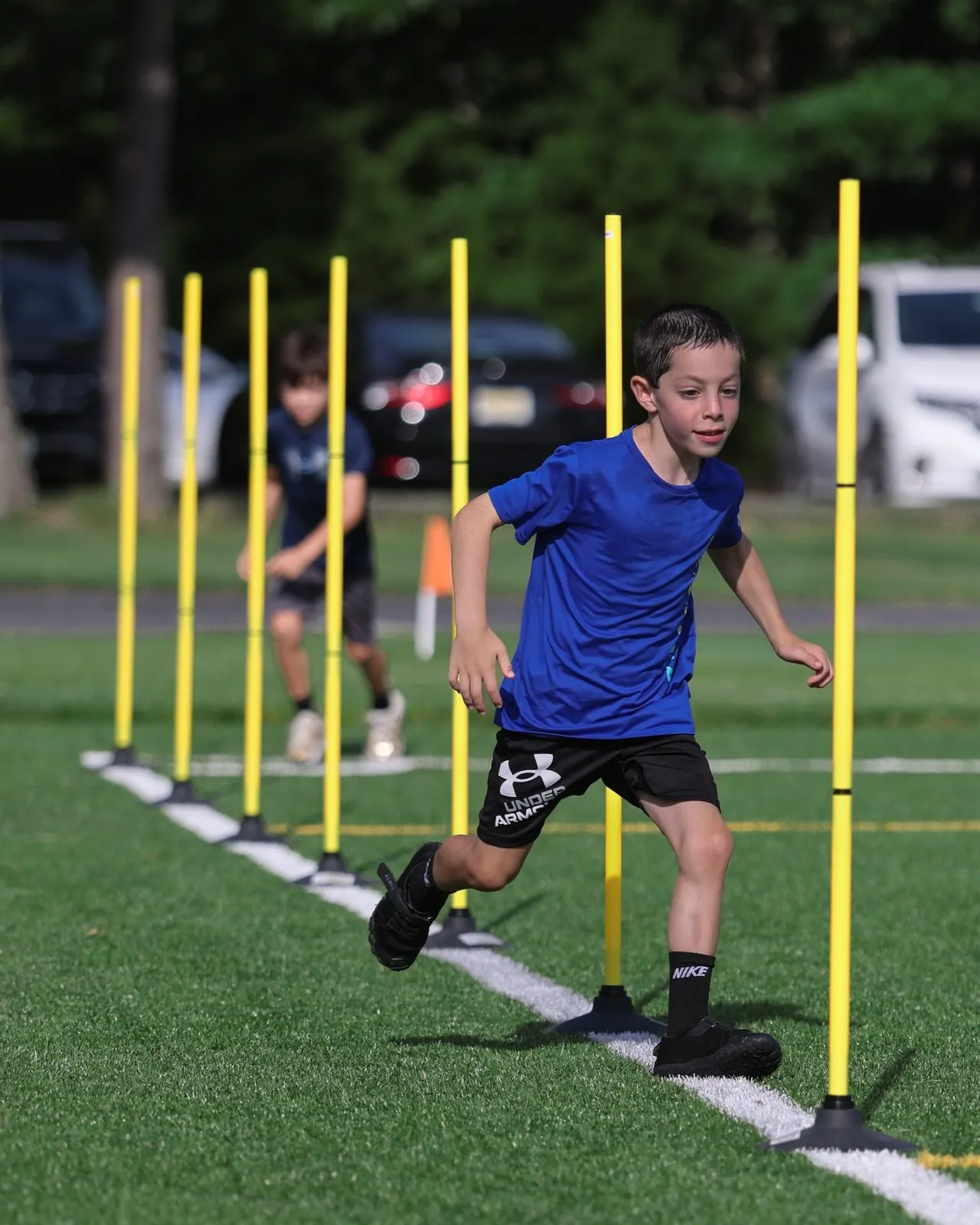 A young KPM athlete cutting through a pole grid on turf